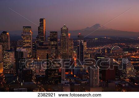 Stock Image - Seattle, Washington and Mount Rainier taken from the Seattle Space Needle just after sunset; Seattle, Washington, United States of America. Fotosearch