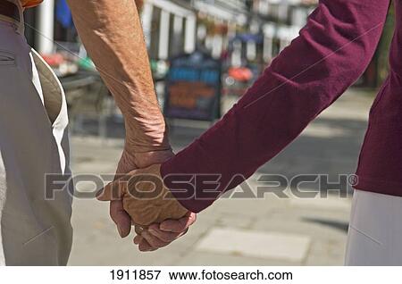Senior Couple Holding Hands, Mid Section, Pantiles, Tunbridge Wells, Kent, Uk View Large Photo Image Stock Photo - Senior Couple Holding Hands, Mid Section, Pantiles, Tunbridge Wells, Kent, Uk. Fotosearch