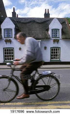 Stock Photograph - Senior Man Cycling In Village. Fotosearch