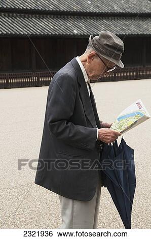 Stock Photograph - Senior man looking at map; Tokyo, Japan. Fotosearch