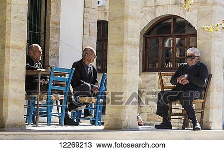Stock Image - Senior men sitting and talking together; Arsos, Limassol, Cyprus. Fotosearch