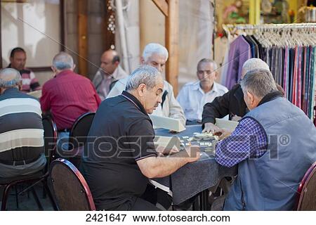 Stock Photo - Senior men sitting around tables playing games; Urgup, Cappadocia, Turkey. Fotosearch