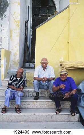 Stock Image - Senior Men Sitting On Steps; Chiaorella, Procida, Italy. Fotosearch