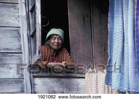 Stock Image - Senior Woman Leaning On Windowsill; Mount Data, Philippines. Fotosearch