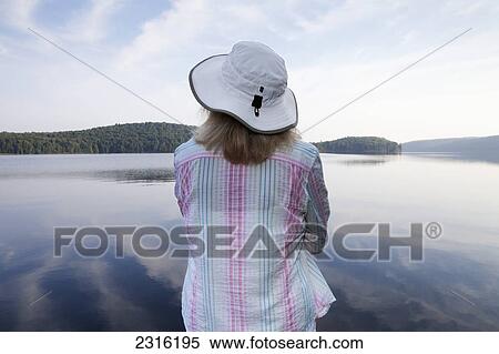 Stock Photography - Senior Woman Looking Out At Lake At Algonquin Park; Ontario Canada. Fotosearch