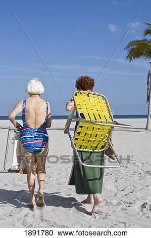 Senior Women Carrying Deck Chairs Walking On Beach View Large Photo Image Stock Image - Senior Women Carrying Deck Chairs Walking On Beach. Fotosearch