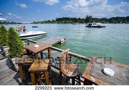 Serbia., River Danube; Belgrade, floating on river, Small boat passing by. tables and chairs. Cafe Bars View Large Photo Image Stock Image - Serbia., River Danube; Belgrade, floating on river, Small boat passing by. tables and chairs. Cafe Bars. Fotosearch