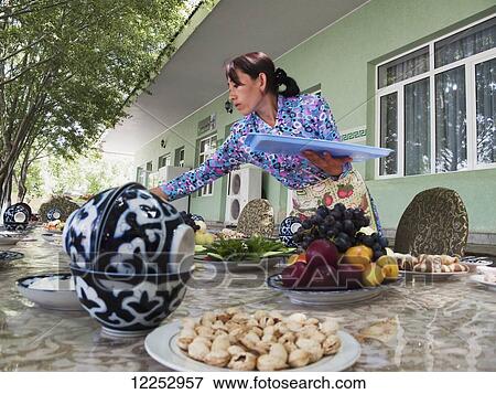 Stock Photo - Serving local food for an outdoor meal; Jizzakh, Uzbekistan. Fotosearch