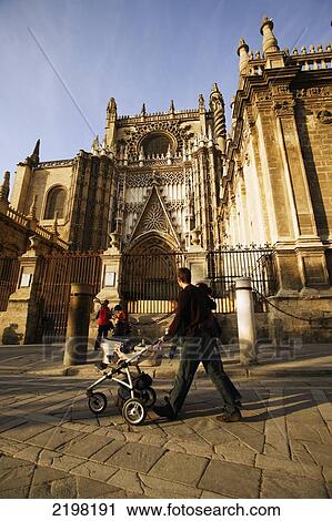 Stock Image - Seville, Spain. People Walking By Cathedral Gilrada. Fotosearch
