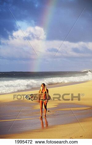 Sexy Girl In String Bikini Walking Along The Beach Holding Surfboard, Rainbow Behind. View Large Photo Image Stock Image - Sexy Girl In String Bikini Walking Along The Beach Holding Surfboard, Rainbow Behind.. Fotosearch