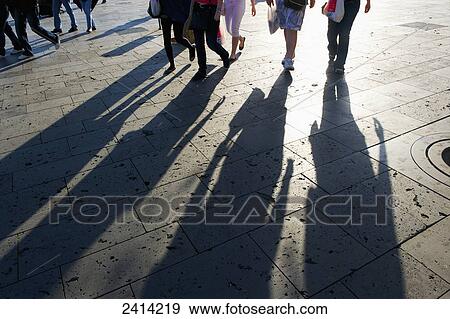 Stock Photo - Shadows of pedestrians at sunrise; Barcelona, Spain. Fotosearch