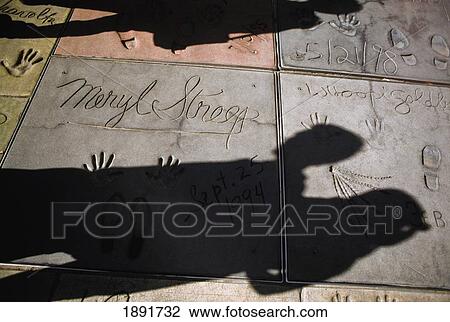 Stock Image - Shadows On Handprints Of Movie Stars Outside Mann's Chinese Theatre. Fotosearch