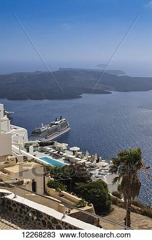 Stock Image - Ships in the harbour of Thera, with the Island of Nea Kameni in the background; Thera, Santorini, Greece. Fotosearch