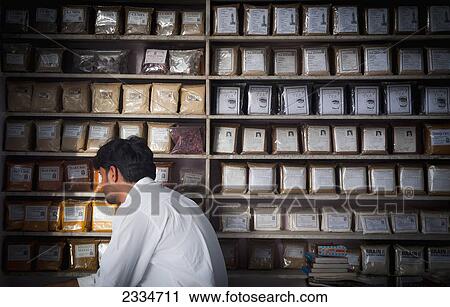 Stock Image - Shop Assistant With Spices Store; Jodhpur, Rajasthan, India. Fotosearch