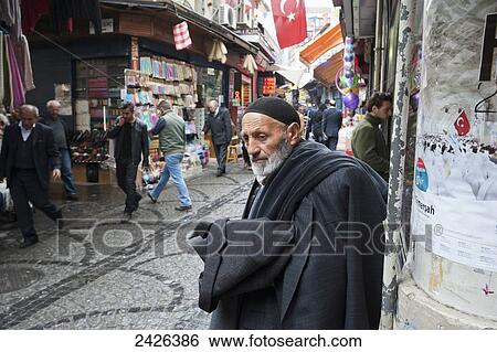 Stock Photograph - Shops along a street with a turkish flag hanging overhead; Istanbul, Turkey. Fotosearch
