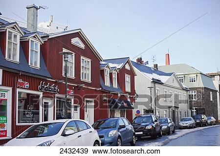 Shops and residential buildings with parked cars along a wet street: Reykjavik, Iceland View Large Photo Image Stock Photo - Shops and residential buildings with parked cars along a wet street: Reykjavik, Iceland. Fotosearch