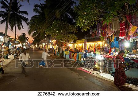 Stock Image - Shops at dusk on street; Candolim, Goa, India. Fotosearch