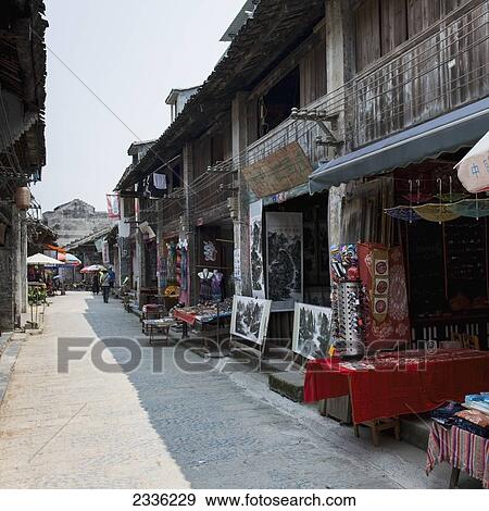 Stock Photo - Shops Open With Tables Displaying Their Wares; Yangshuo, Guangxi, China. Fotosearch