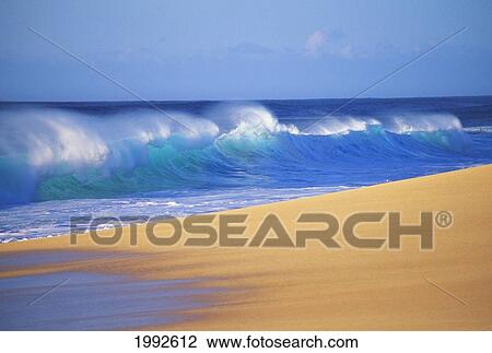 Stock Image - Shorebreak Waves Along Sandy Beach, Blue Sky. Fotosearch