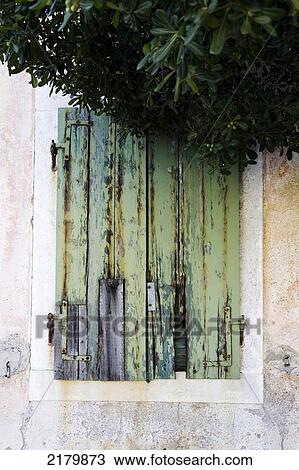 Stock Image - Shutters With Peeling Paint And Tree, Kotor Monte. Tif. Fotosearch