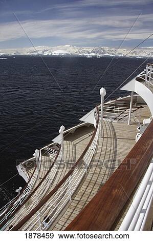 Stock Photo - Side Of Cruise Ship With Mountains In Background. Fotosearch