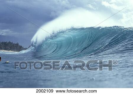 Stock Photo - Side View Of Large Wave, Curl, White Wash, Land And Sky Visible, Spray. Fotosearch