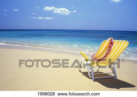 Stock Photo - Side View Of Yellow Beach Chair With Lei, Calm Blue Water, Blue Sky. Fotosearch