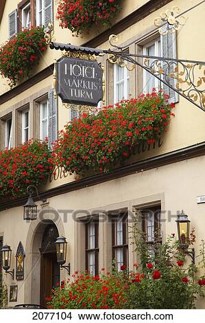 Picture - Sign For A Hotel Hanging From The Side Of The Building With Blossoming Red Flowers In Window Planter Boxes; Rothenburg Ob Der Tauber Bavaria Germany. Fotosearch