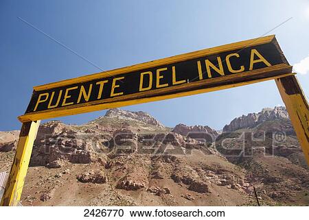 Stock Image - Sign for Puente del Inca against a blue sky; Mendoza, Argentina. Fotosearch