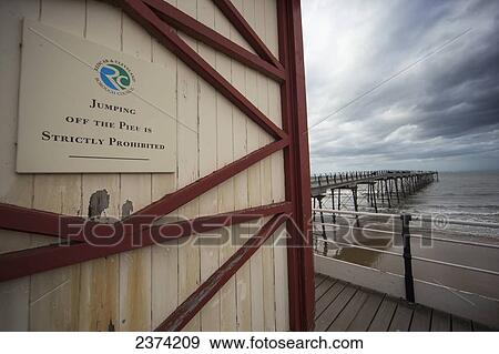 Stock Photo - Sign on the side of a building to prohibit jumping off the pier; Saltburn, North Yorkshire, England. Fotosearch