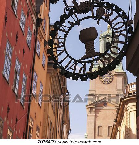 Stock Photo - Sign On The Side Of A Building With A Clock Tower In The Background; Stockholm Sweden. Fotosearch