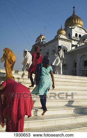 Stock Image - Sikhs at the Gurudwara Bangla Sahib, a place of worship in Delhi. Gurudwara Bangla Sahib is the most prominent Sikh gurdwara in Delhi. The temple has a fine golden cupola and a sacred pool of water known as the Saroyar. The holy shrine was constructed. Fotosearch
