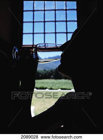 Stock Photo - Silhouette Of A Person Drinking From A Glass With A View Of Mountains Out The Window. Fotosearch
