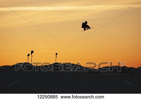 Stock Photography - Silhouette of a snowboarder jump in mid-air at sunset; Norway. Fotosearch