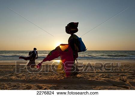 Silhouette of a woman selling Indian cloth on the beach at dusk; Candolim, Goa, India View Large Photo Image Picture - Silhouette of a woman selling Indian cloth on the beach at dusk; Candolim, Goa, India. Fotosearch