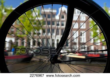 Silhouette of bicycle wheel in front of canal and traditional gabled houses; Amsterdam, Holland View Large Photo Image Stock Photo - Silhouette of bicycle wheel in front of canal and traditional gabled houses; Amsterdam, Holland. Fotosearch