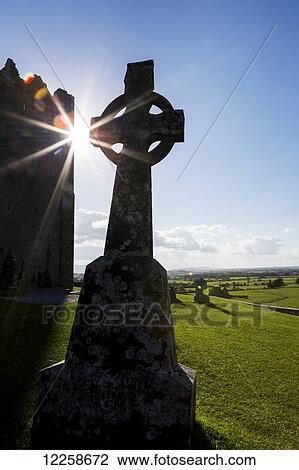 Silhouette of celtic cross with sunburst and castle tower in background; Cashel, County Tipperary, Ireland View Large Photo Image Stock Image - Silhouette of celtic cross with sunburst and castle tower in background; Cashel, County Tipperary, Ireland. Fotosearch