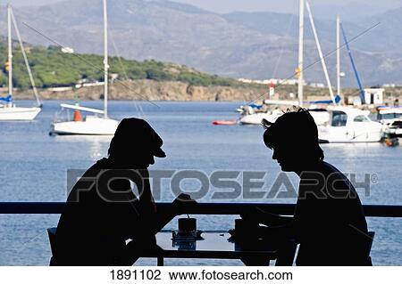 Stock Image - Silhouette Of Couple In Cafe At Port De La Selva. Fotosearch