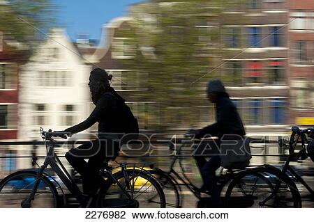 Silhouette of cyclists going past canal and gabled houses; Amsterdam, Holland View Large Photo Image Stock Image - Silhouette of cyclists going past canal and gabled houses; Amsterdam, Holland. Fotosearch