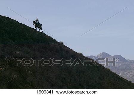 Stock Image - Silhouette Of Horse Rider On Hill, Moulay Idriss, Morocco. Fotosearch