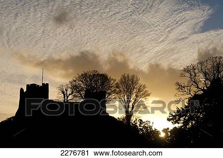 Stock Image - Silhouette of Lewes Castle with mackerel sky behind at dusk; Lewes, East Sussex, England. Fotosearch