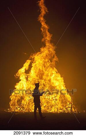 Stock Photo - Silhouette Of Man In Military Unifrom In Front Of Large Bonfire At Barcombe Bonfire Night, Barcombe, East Sussex, Uk. Fotosearch