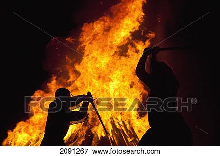 Stock Photo - Silhouette Of Men Dressed As Norman Soldiers In Front Of Large Bonfire On Beach, Hastings Bonfire Night, East Sussex, Uk. Fotosearch