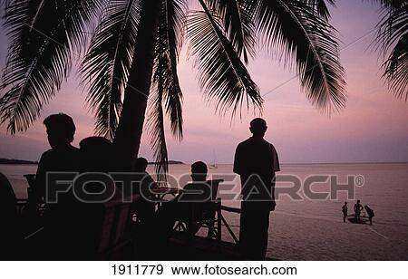 Silhouette Of People Relaxing Under Palm Tree At Dusk, Koh Samui, Thailand View Large Photo Image Stock Photo - Silhouette Of People Relaxing Under Palm Tree At Dusk, Koh Samui, Thailand. Fotosearch