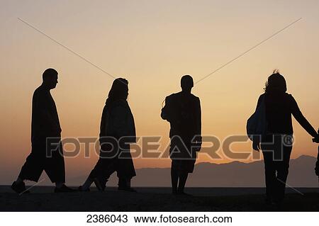 Silhouette of people standing and walking at sunrise; California, United States of America View Large Photo Image Stock Image - Silhouette of people standing and walking at sunrise; California, United States of America. Fotosearch