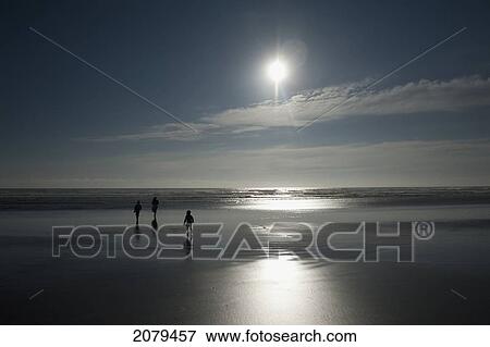 Stock Photo - Silhouette Of People Walking On The Wet Sand Of Nye Beach; Newport Oregon United States Of America. Fotosearch