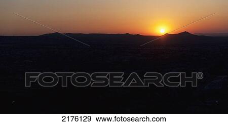 Stock Photo - Silhouette Of The Landscape And An Orange Horizon With A Glowing Sun At Sunset; Aktepe Nevsehir Turkey. Fotosearch
