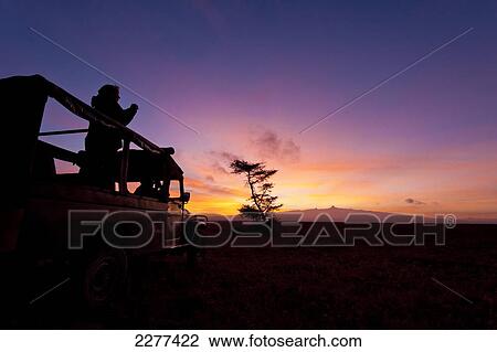Silhouette of tourist and guide in 4x4 in front of Mt Kenya at dawn, Ol Pejeta Conservancy; Kenya View Large Photo Image Stock Image - Silhouette of tourist and guide in 4x4 in front of Mt Kenya at dawn, Ol Pejeta Conservancy; Kenya. Fotosearch