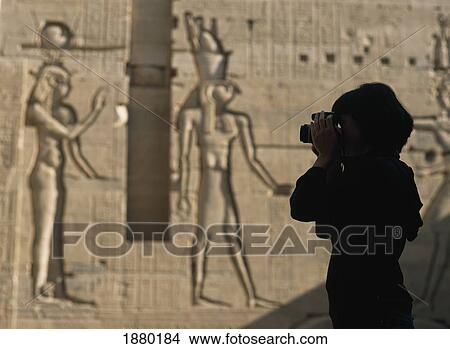 Picture - Silhouette Of Tourist Taking Pictures In Courtyard In Front Of Reliefs. Fotosearch
