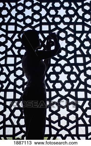 Stock Image - Silhouette Of Tourist Taking Photographs Next To Stone Grill In Humayun's Tomb, Close Up. Fotosearch